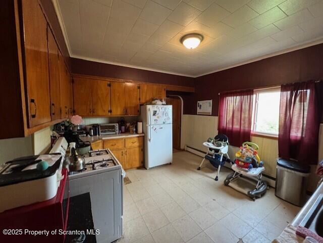 1449 Dickens St, Scranton, PA 18504 - kitchen with white appliances, brown cabinets, light countertops, light flooring, and baseboard heating