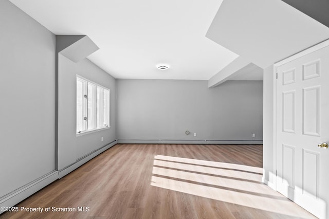 interior space with light wood-type flooring and a baseboard heating unit