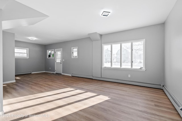 interior space with light hardwood / wood-style flooring and a baseboard heating unit