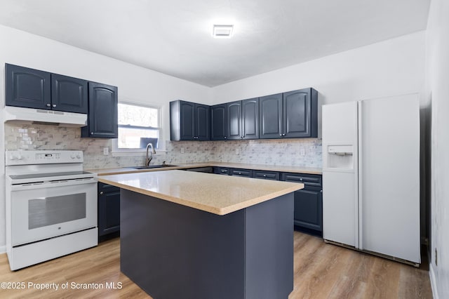 kitchen featuring sink, blue cabinetry, white appliances, a center island, and light hardwood / wood-style floors