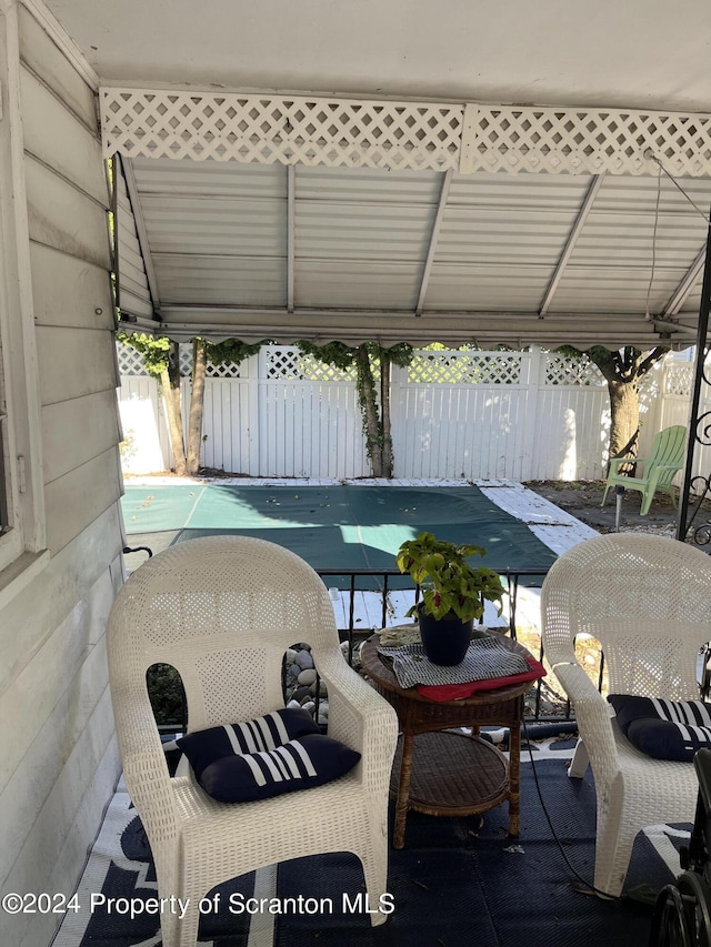 view of patio with a covered pool and fence