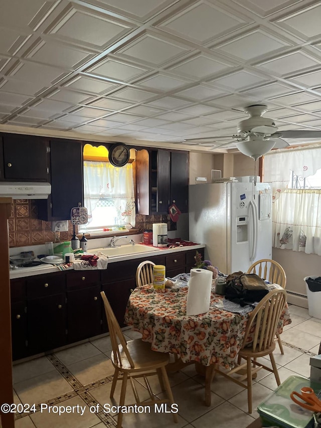 kitchen featuring light tile patterned flooring, ceiling fan, white fridge with ice dispenser, and sink