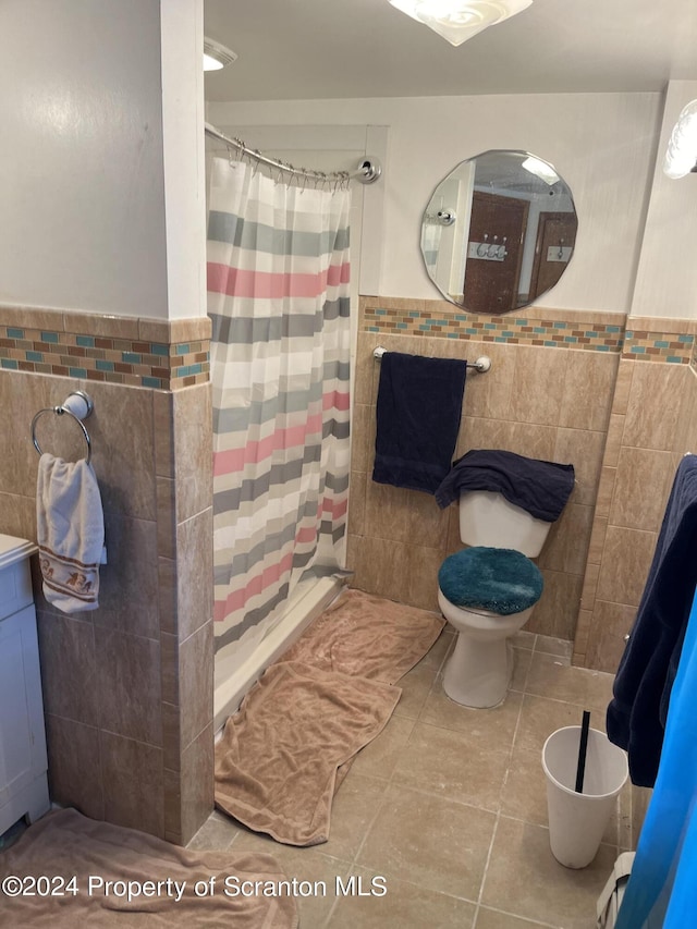 bathroom featuring vanity, a shower with curtain, tile patterned flooring, toilet, and tile walls