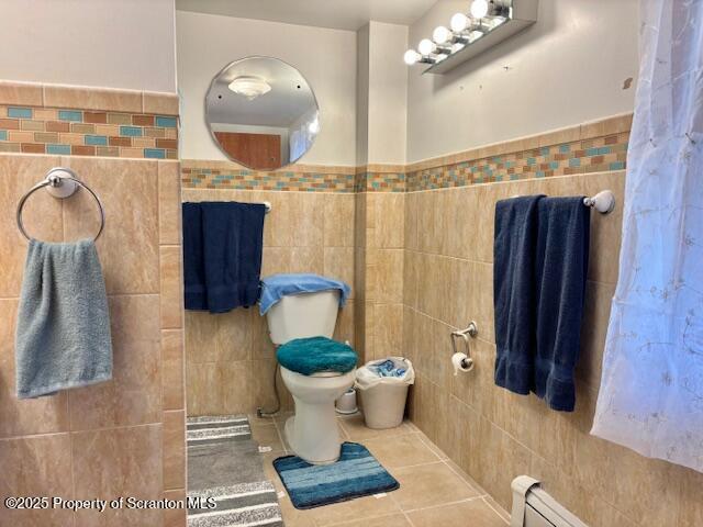 full bath with toilet, tile patterned flooring, and tile walls