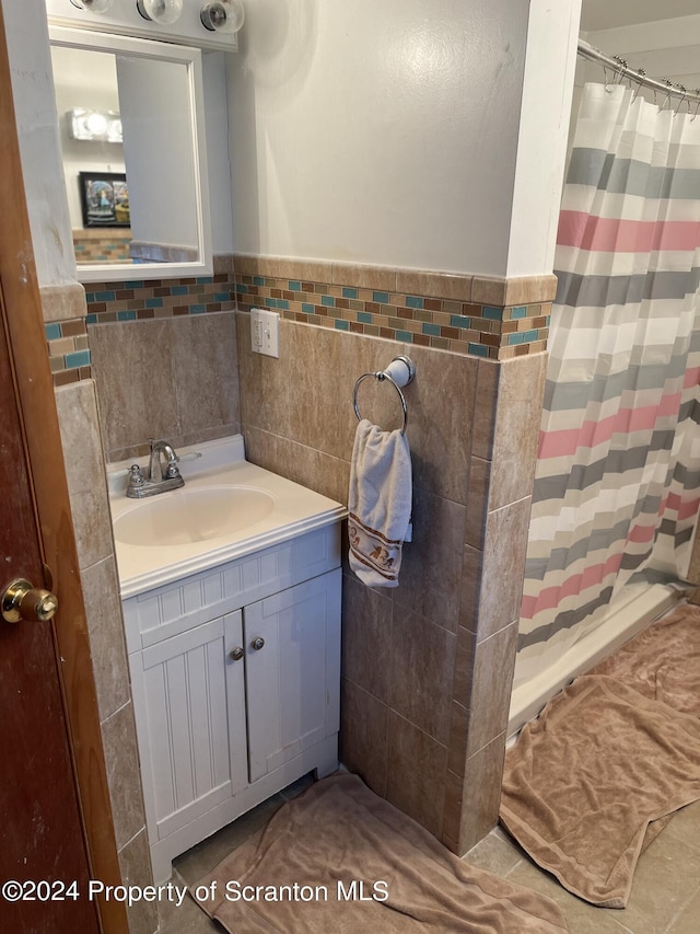 bathroom with a shower with shower curtain, vanity, and tile walls