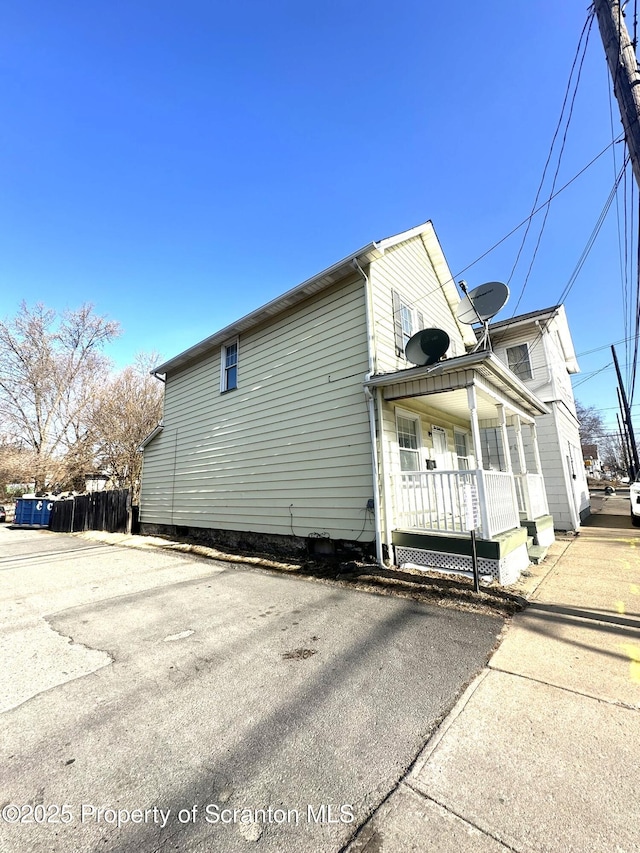 view of side of home featuring covered porch