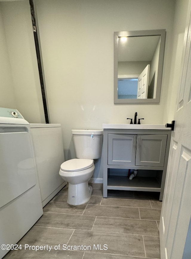 bathroom with vanity, toilet, and washing machine and clothes dryer