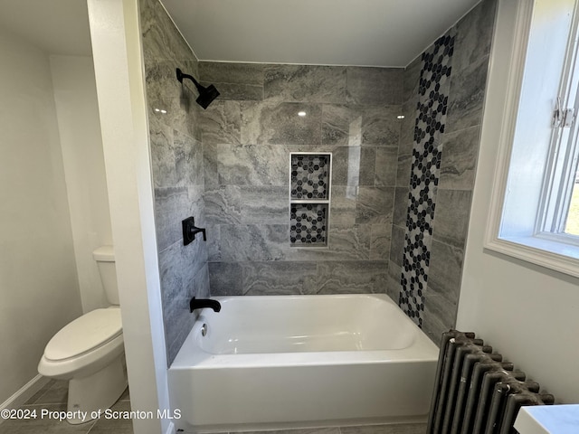 bathroom with tile patterned flooring, radiator heating unit, toilet, and tiled shower / bath