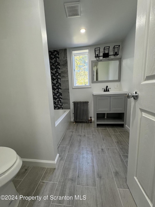 bathroom featuring vanity, toilet, and radiator