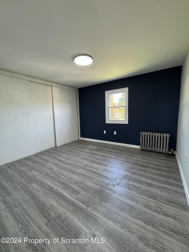 empty room featuring hardwood / wood-style floors and radiator