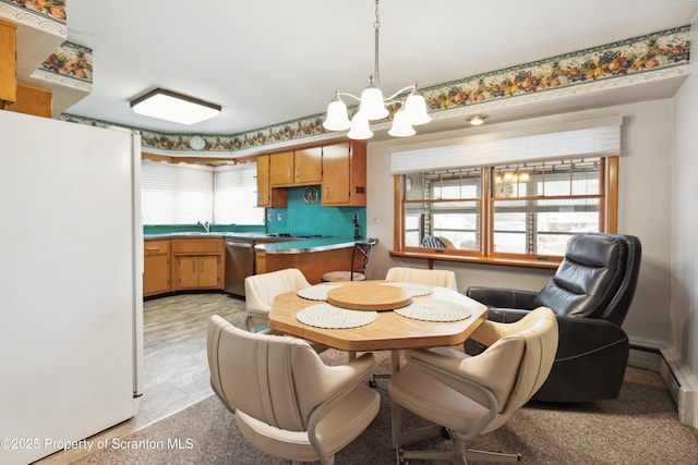 dining space featuring sink and an inviting chandelier