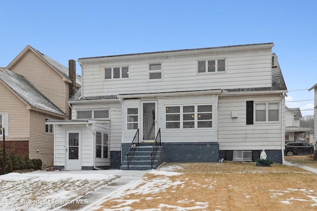 view of snow covered rear of property