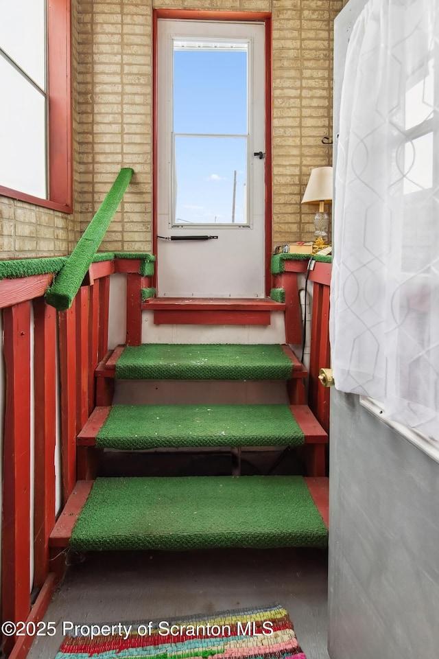 stairway featuring brick wall