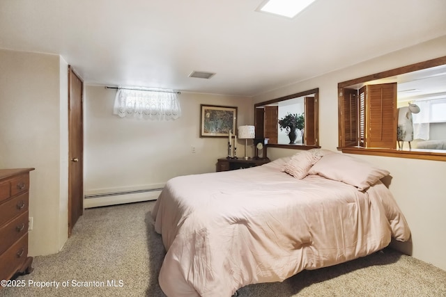 carpeted bedroom featuring a baseboard heating unit