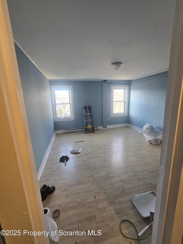 spare room with wood-type flooring, plenty of natural light, and ornamental molding