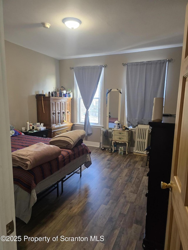 bedroom featuring dark wood-type flooring and radiator heating unit