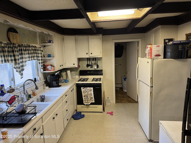 kitchen featuring coffered ceiling, sink, range with gas cooktop, white refrigerator, and white cabinets