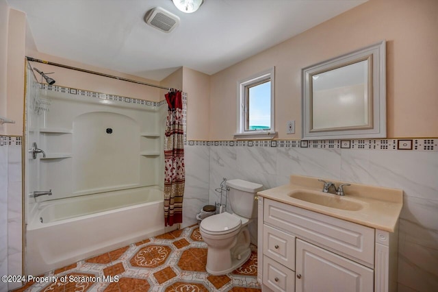 full bathroom featuring tile patterned floors, tile walls, toilet, vanity, and shower / tub combo