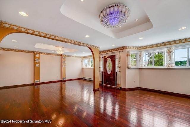 entryway featuring a raised ceiling, a baseboard radiator, dark hardwood / wood-style floors, and an inviting chandelier