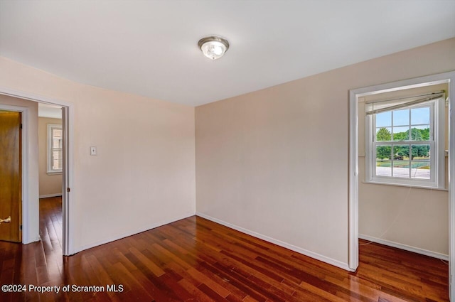 empty room with dark hardwood / wood-style flooring