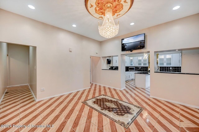 unfurnished living room featuring light tile patterned floors and an inviting chandelier