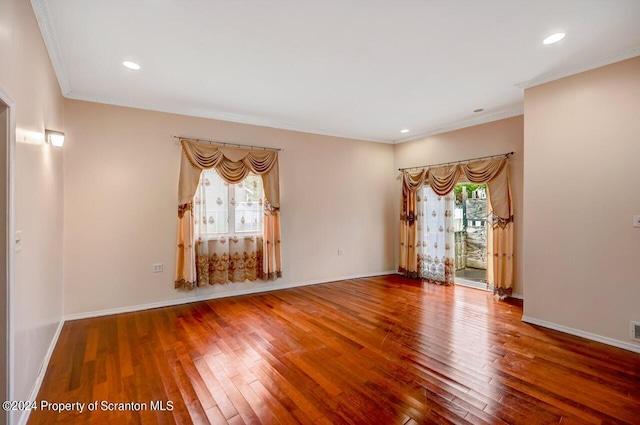 unfurnished room with hardwood / wood-style floors and crown molding