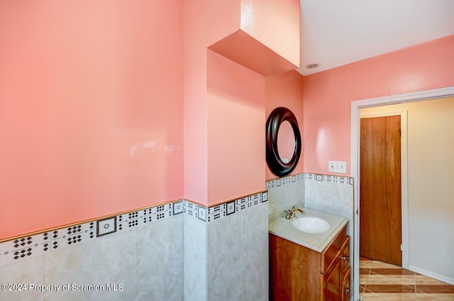 bathroom with tile patterned flooring, vanity, and tile walls