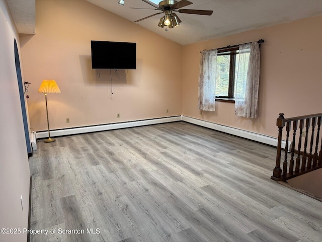 unfurnished living room featuring lofted ceiling, a baseboard radiator, a ceiling fan, and wood finished floors