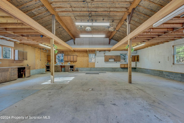 interior space featuring lofted ceiling and unfinished concrete floors