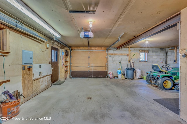 garage featuring concrete block wall, electric panel, and a garage door opener