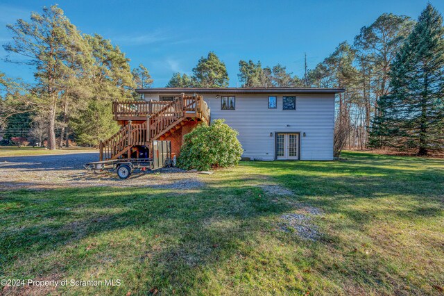 rear view of property with a yard, french doors, stairway, and a wooden deck