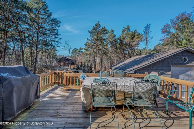 wooden terrace featuring grilling area and outdoor dining space