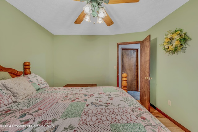 bedroom featuring a ceiling fan, baseboards, and wood finished floors