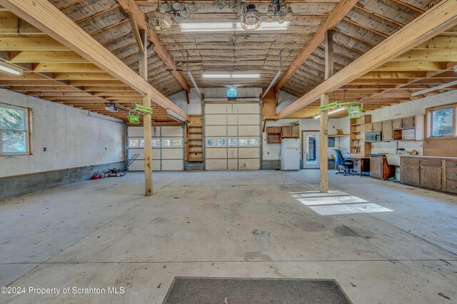 garage with a garage door opener and freestanding refrigerator