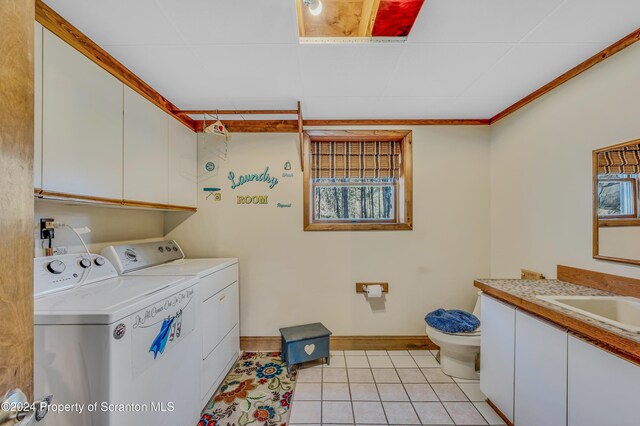 clothes washing area featuring light tile patterned floors, ornamental molding, a sink, independent washer and dryer, and baseboards