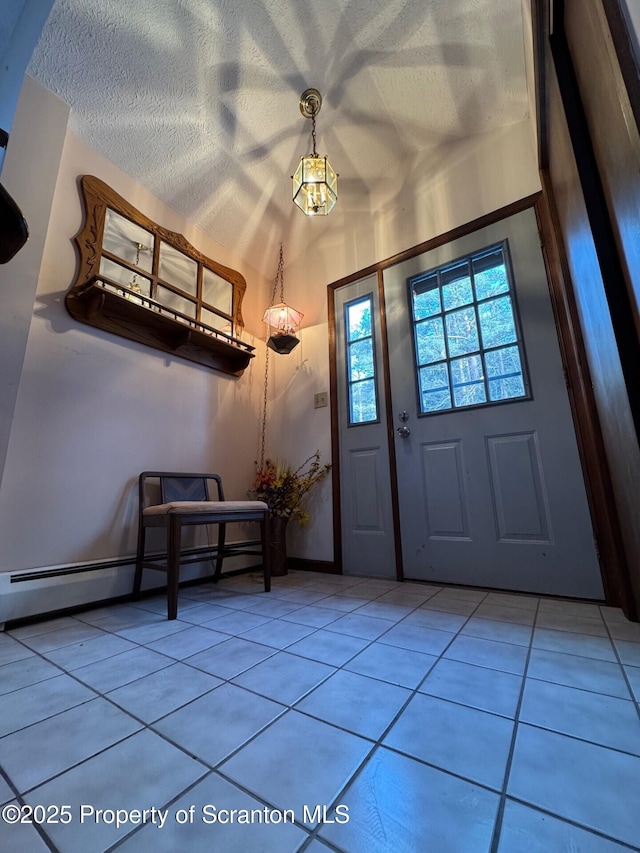 entryway featuring light tile patterned floors, lofted ceiling, a baseboard heating unit, a textured ceiling, and baseboards