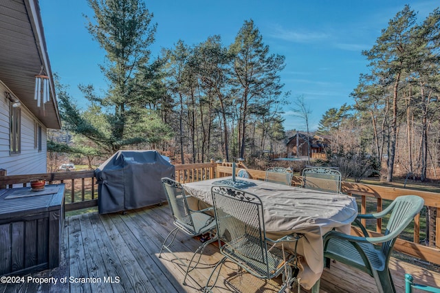 wooden deck with outdoor dining space and a grill