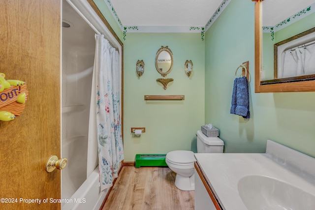 bathroom with a textured ceiling, toilet, wood finished floors, vanity, and baseboards