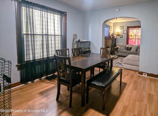1110-1112 W Elm St, Scranton, PA 18504 - dining room featuring arched walkways, light wood-type flooring, and baseboards