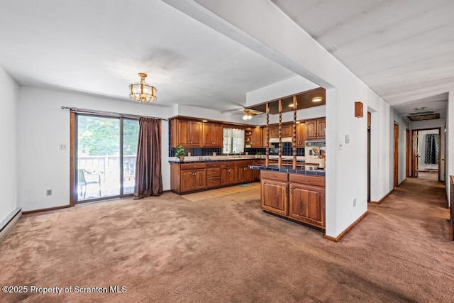 1103 Quarry Rd, Old Forge, PA 18518 - kitchen with dark countertops, brown cabinets, light carpet, a chandelier, and oven