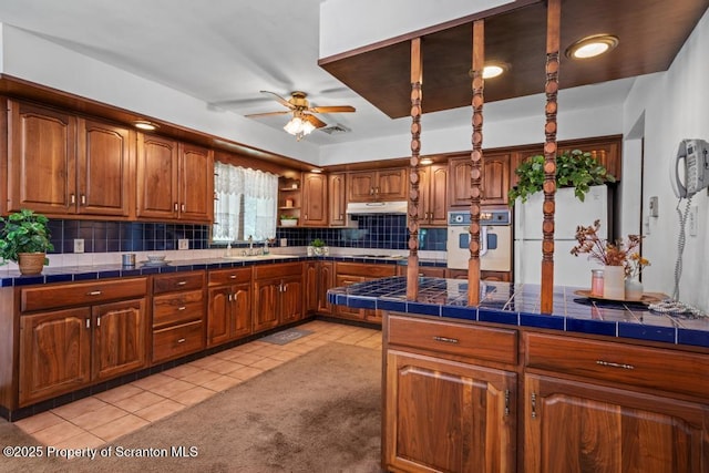 1103 Quarry Rd, Old Forge, PA 18518 - kitchen featuring white oven, under cabinet range hood, a ceiling fan, brown cabinetry, and light tile patterned flooring