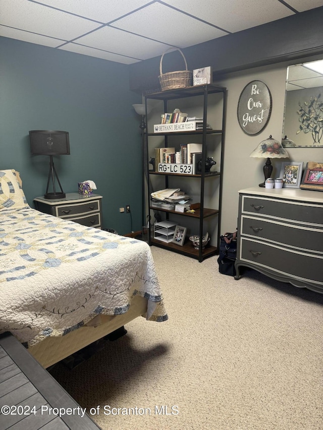 bedroom featuring a paneled ceiling and carpet flooring