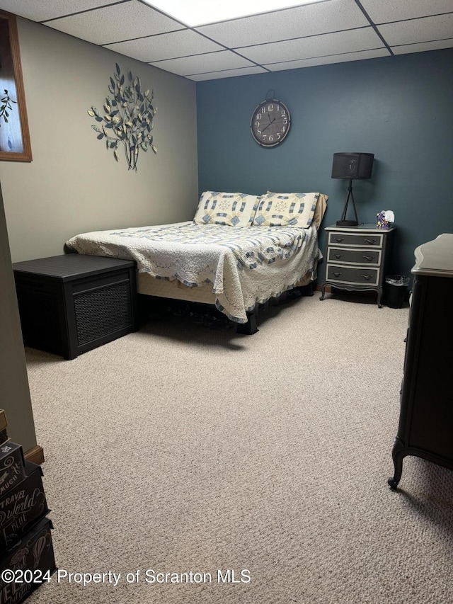 bedroom featuring carpet floors and a drop ceiling