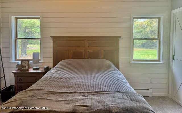 3365 Lake Of Meadows Rd, Little Meadows, PA 18830 - bedroom featuring light colored carpet, multiple windows, a baseboard heating unit, and wooden walls