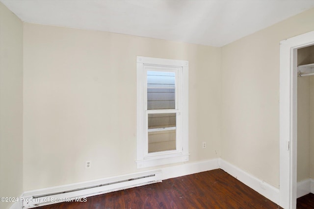 unfurnished room featuring hardwood / wood-style floors and baseboard heating