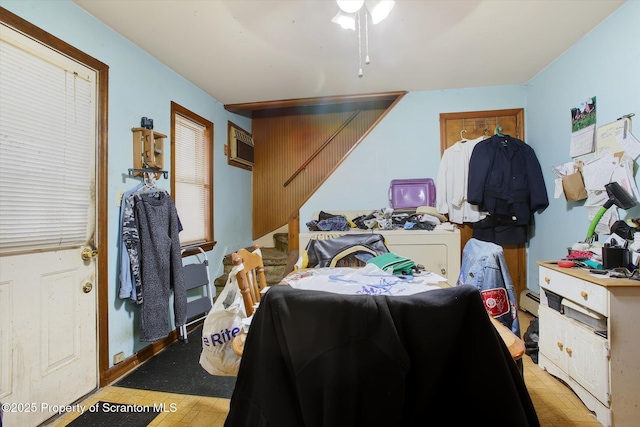 bedroom featuring a wall mounted AC, ceiling fan, and baseboard heating