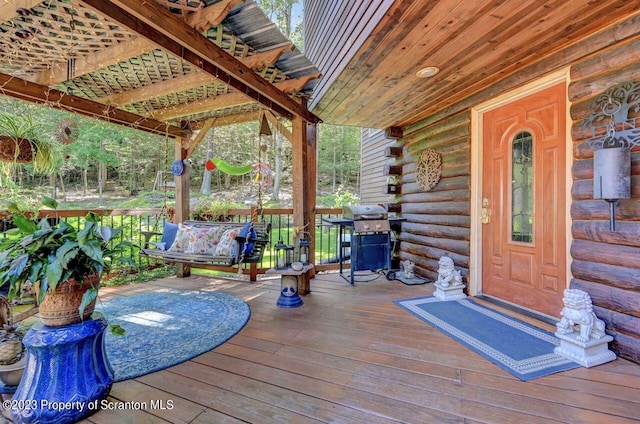 wooden terrace featuring a porch and a grill