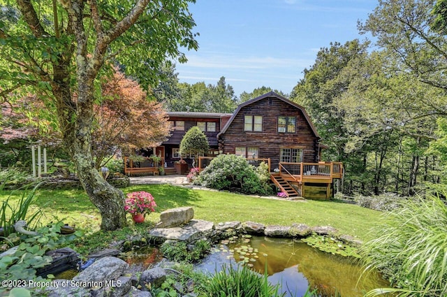 back of house with a wooden deck and a yard