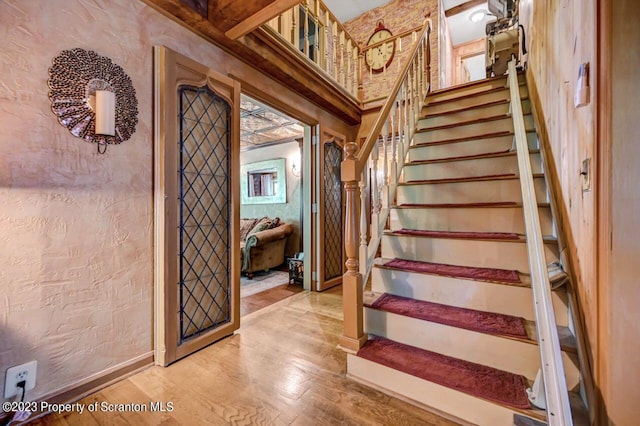 staircase with hardwood / wood-style floors