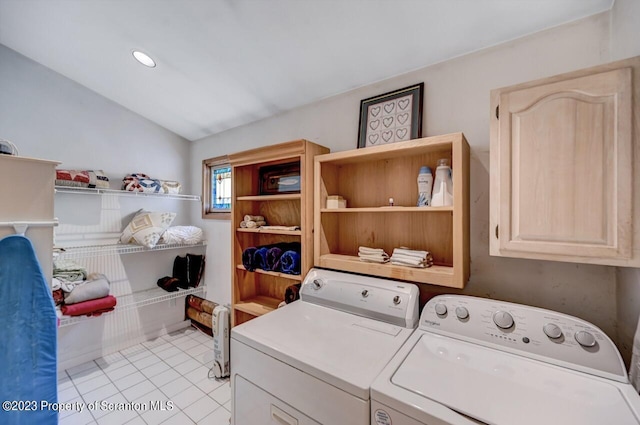 laundry area with cabinets, washing machine and dryer, and light tile patterned floors